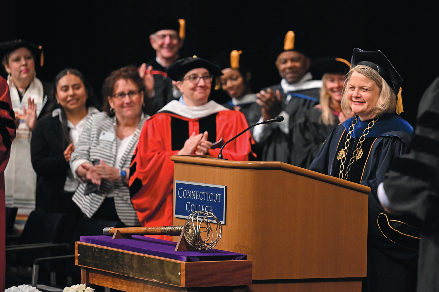 An image of President Chapdelaine smiling at the podium during Inauguration while others clap