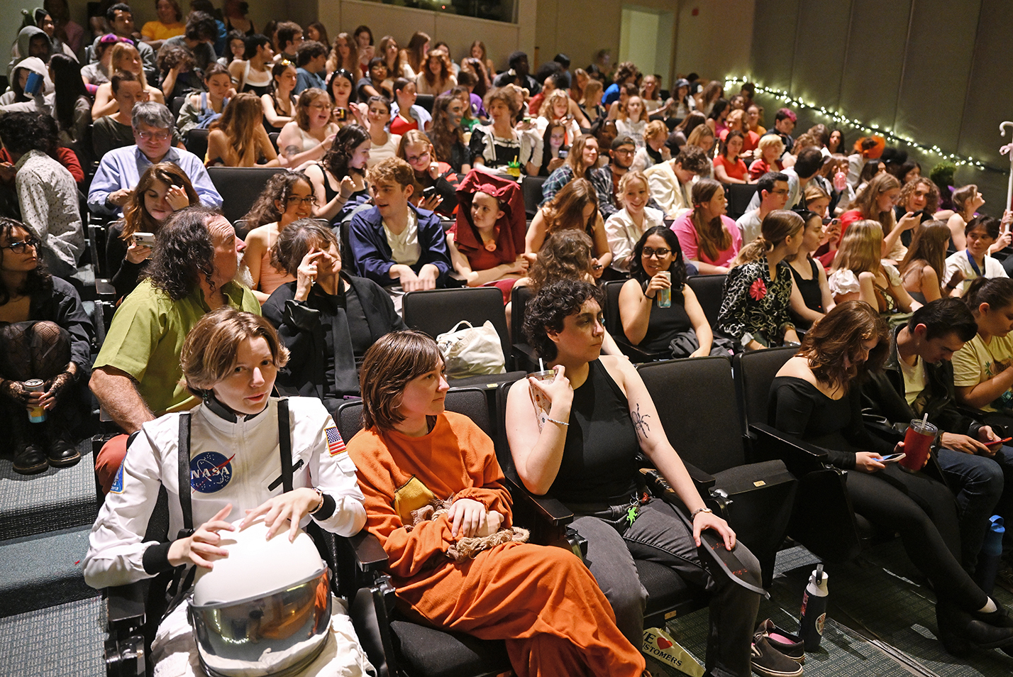 An auditorium full of costumed students waits for a screening of The Rocky Horror Picture Show to start.