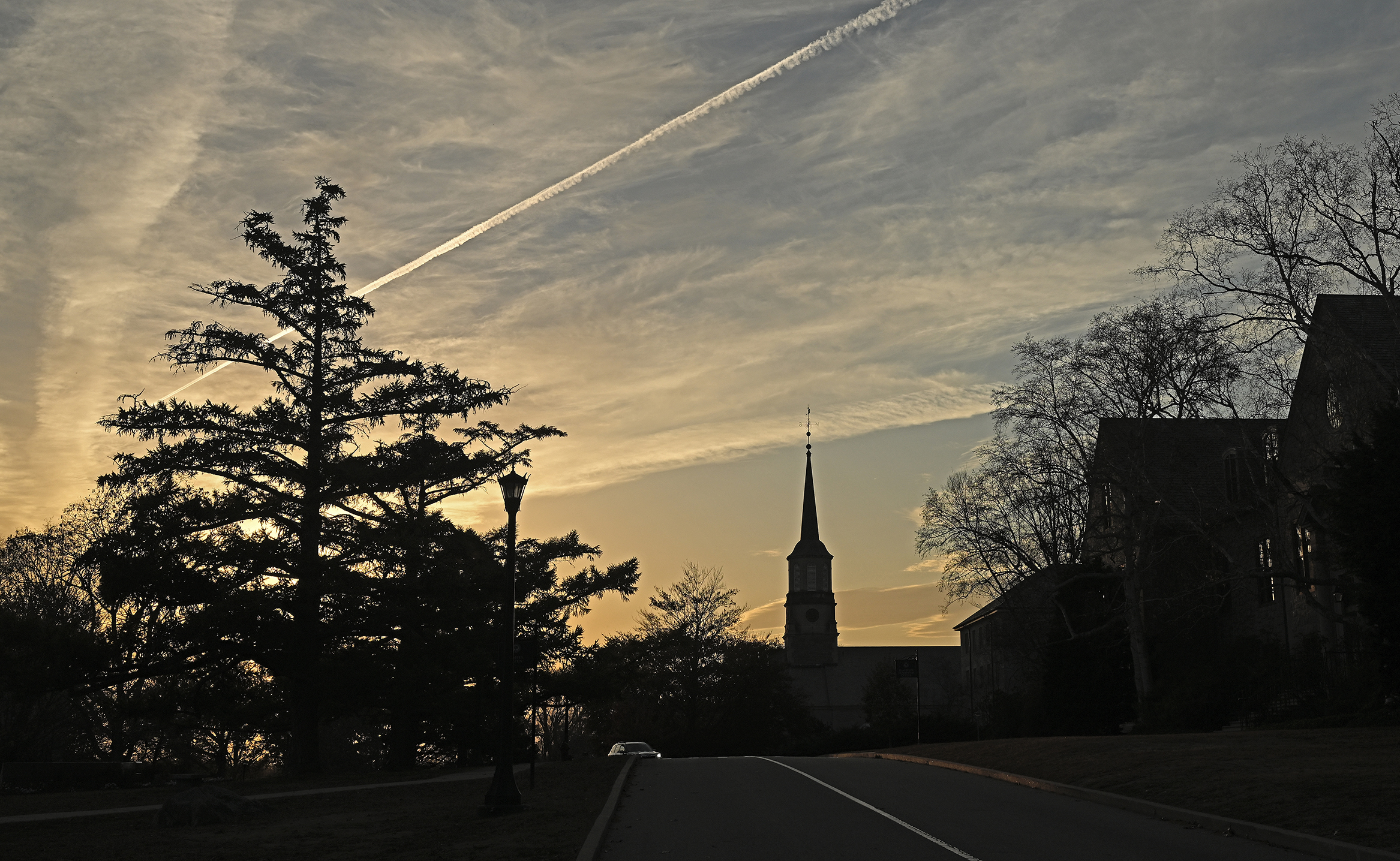 A chapel steeple stands out against the evening sky at dusk.