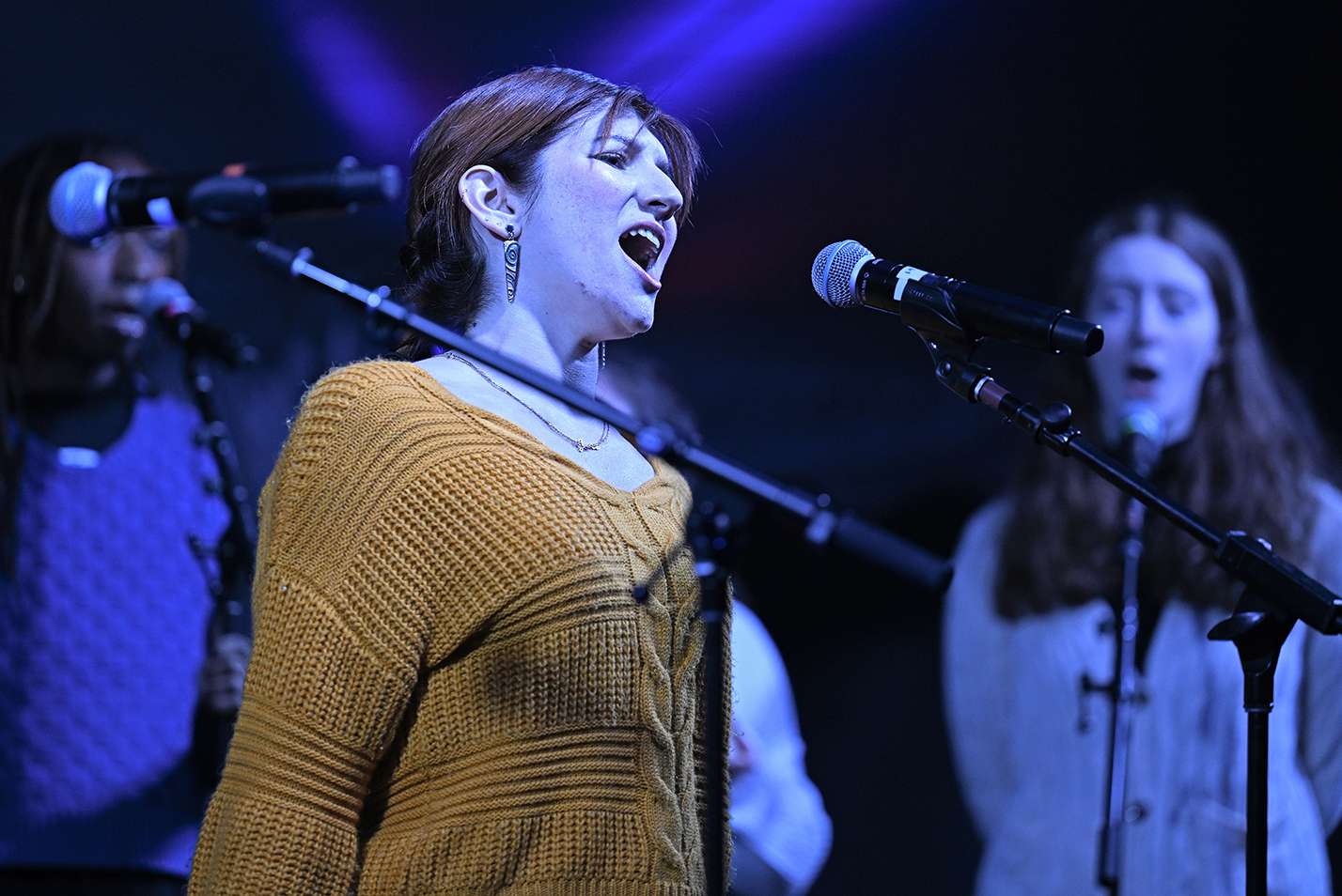 An a cappella singer belts out a solo on stage.