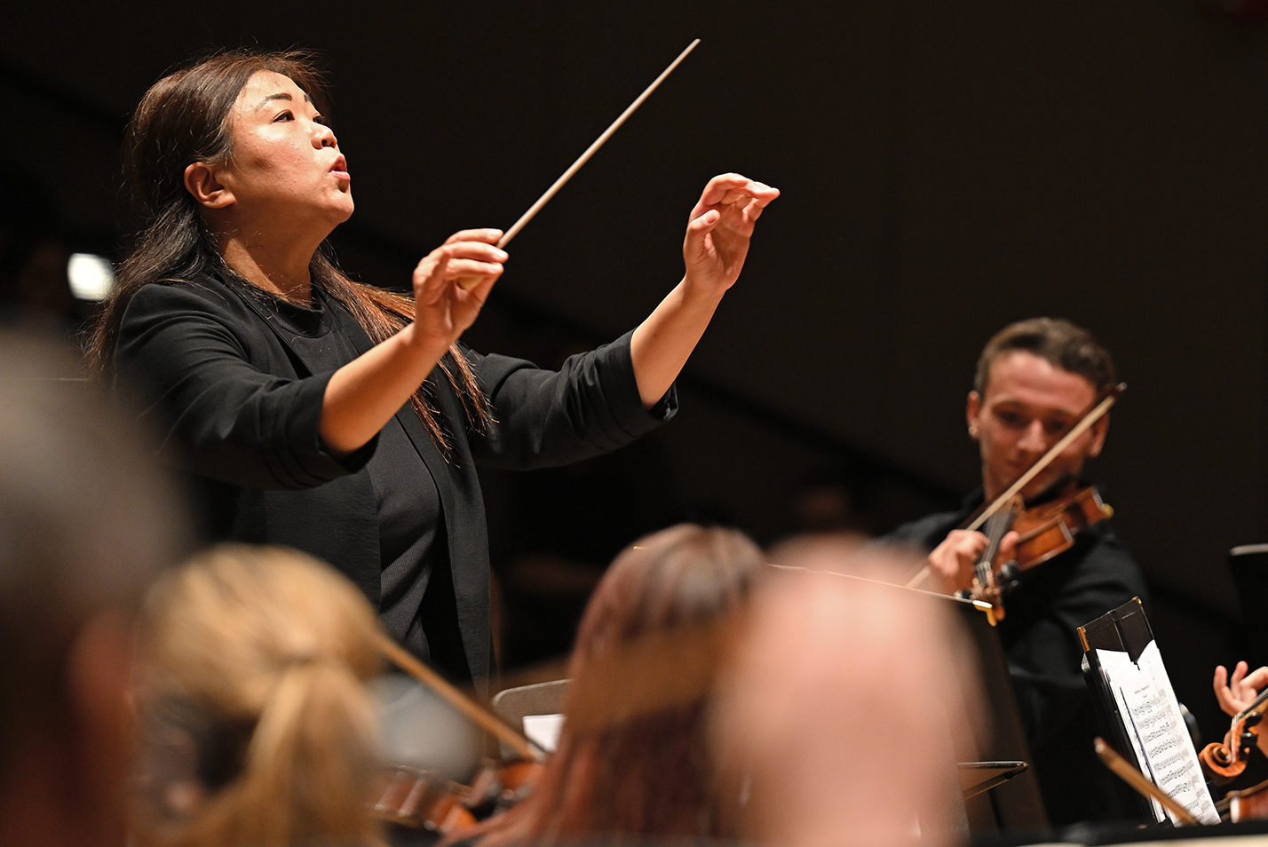 A music professor conducts the student orchestra.