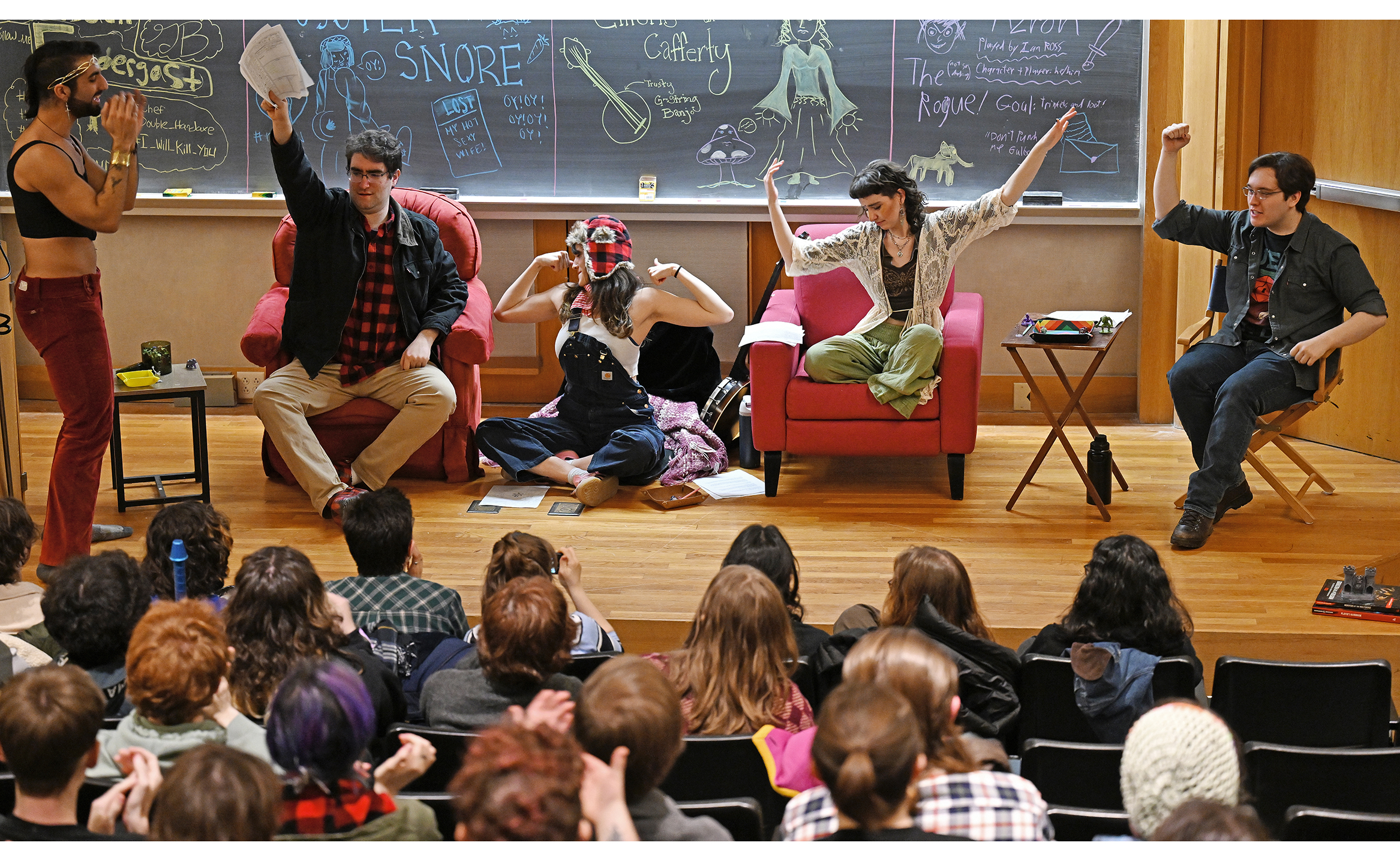 A group of students strike poses as they are introduced during a live Dungeons & Dragons game.